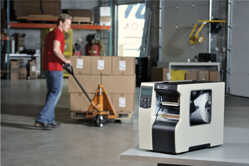 Zebra 110xi4 Barcode Printer in a Warehouse with man pushing a dolly