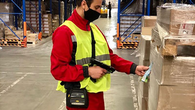 Warehouse worker in red shirt scanning barcodes